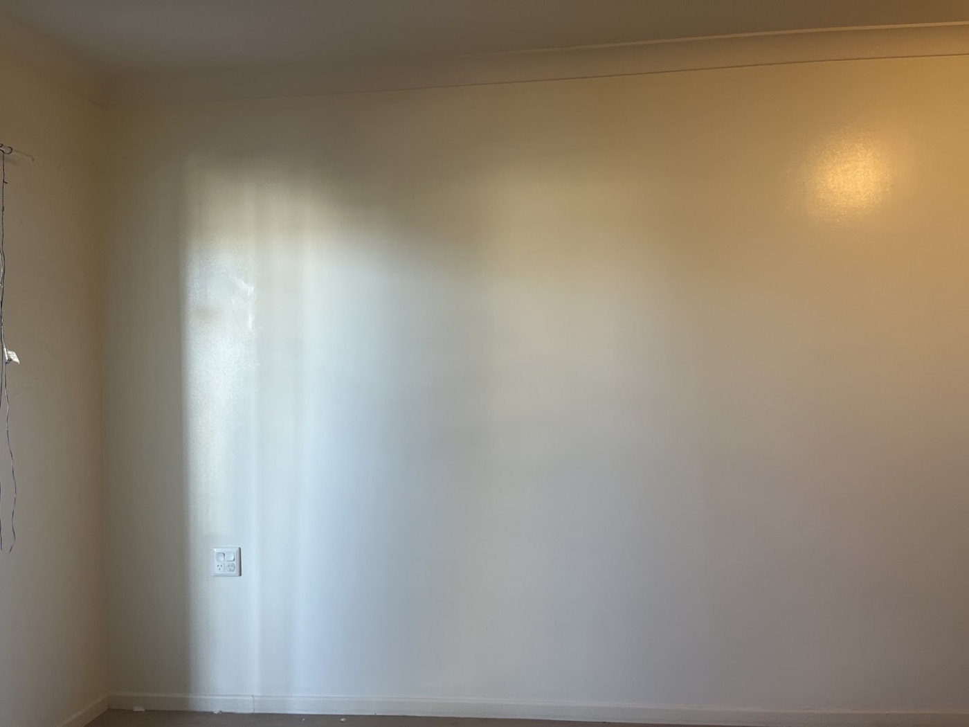 A finished plasterboard wall corner in warm afternoon light