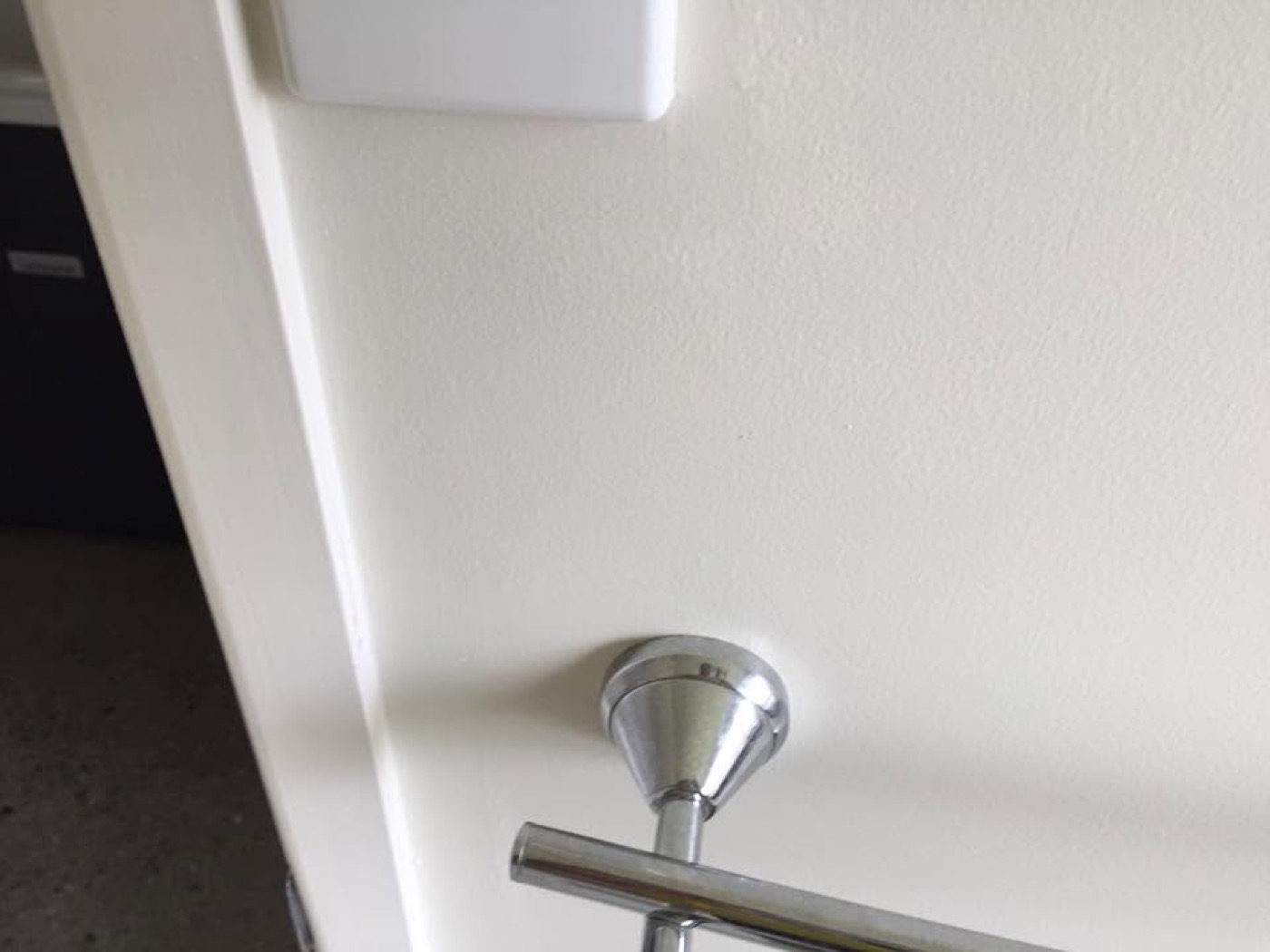 A chrome towel rail mounted level on a bathroom wall