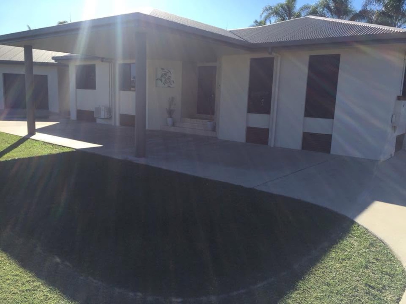 A concrete driveway and path running past a rendered home