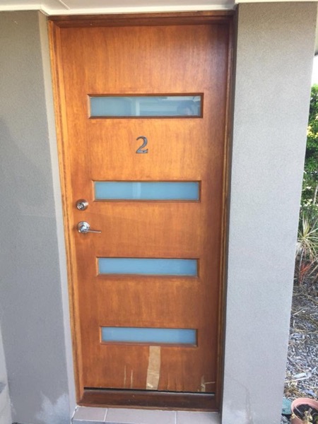 A timber front door with glass panels viewed straight on